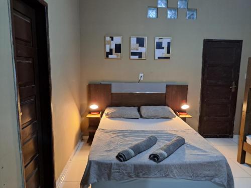 um quarto com uma cama com duas almofadas em Casa ampla e agradável com piscina e churrasqueira em Juazeiro