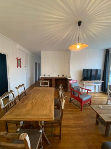 Apt familial plein centre de Lisieux refait à neuf في ليزيو: غرفة معيشة مع طاولة وكراسي خشبية