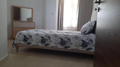 een slaapkamer met een bed met een deken en een spiegel bij Appartement Lac1 in Berges Du Lac