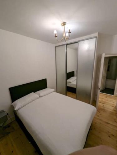 ブレントウッドにあるCozy 2 Beds Brentwood Flatのベッドルーム(白いベッド1台、鏡付)