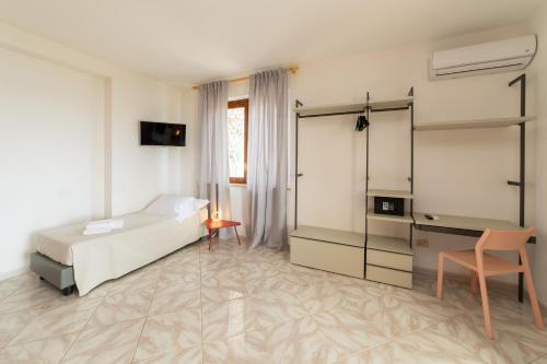 a bedroom with a bed and a desk and a chair at Resort Santa Maria Hotel in Birgi Vecchi