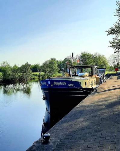 a boat is docked next to a walkway next to the water at St Johns old Schoolhouse in Lecarrow