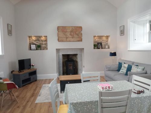 a living room with a table and a couch at St Johns old Schoolhouse in Lecarrow