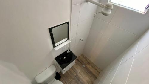 een badkamer met een toilet en een televisie aan de muur bij Pousada Santiago Morumbi in Sao Paulo