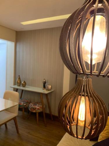 a living room with a large light hanging from the ceiling at Maravilhoso apartamento 2 quartos com ofurô Porto da Barra Salvador Summer Barra Flat in Salvador