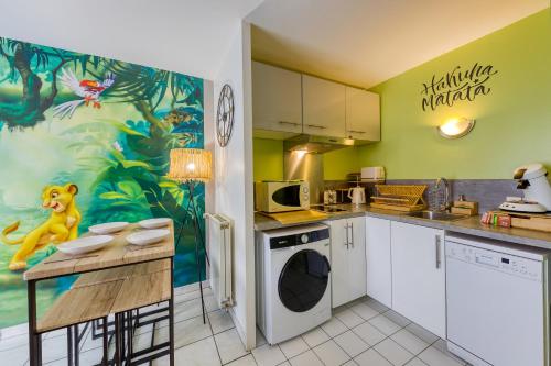 une cuisine avec un tableau de singe sur le mur dans l'établissement Cosy home / Disney / jungle, à Serris