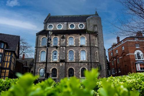 an old brick building with a tower with windows at St Nicholas Boutique Hotel in Shrewsbury