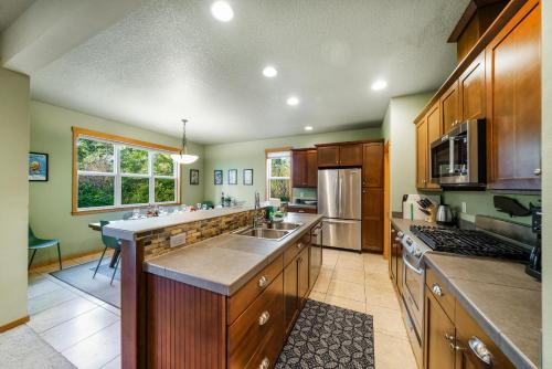 a large kitchen with wooden cabinets and a sink at Sandpiper House-Manzanita Or in Manzanita
