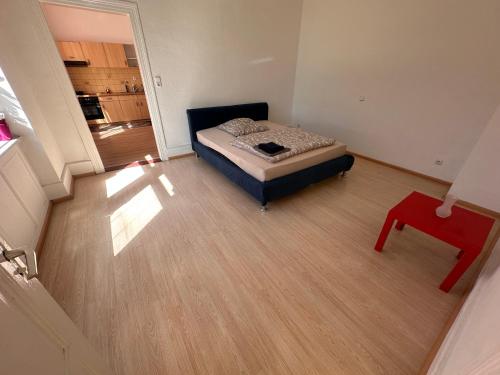 een kleine slaapkamer met een bed en een rode tafel bij Ferienwohnung Rheinfelden in Rheinfelden