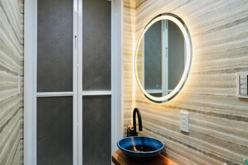a bathroom with a round mirror and a sink at 京都駅すぐ二階建貸切町屋 in Kyoto
