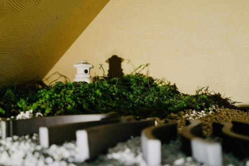 a toy lighthouse sitting on top of a pile of grass at 京都駅すぐ二階建貸切町屋 in Kyoto