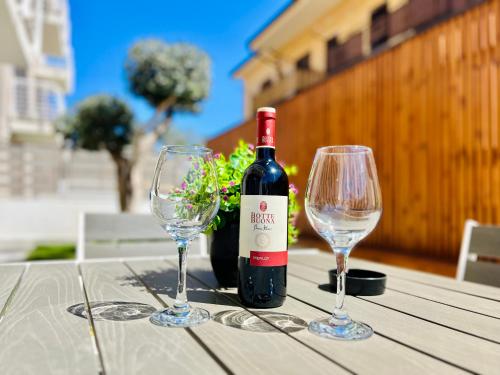 una bottiglia di vino e due bicchieri di vino su un tavolo di Meravigghia a Terrasini