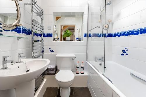 biała łazienka z toaletą i umywalką w obiekcie Re-imagined Stone Barns in the Country Near the Coast w mieście Padstow