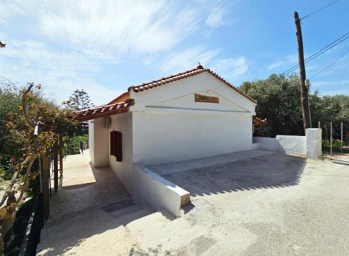 a small white house with a fence next to it at Lemon Nest in Marathokampos