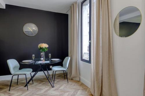 een eetkamer met een tafel en witte stoelen bij Appart luxueux hyper-centre/15mn Fontainebleau in Montereau-faut-Yonne