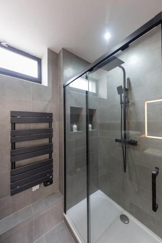 une salle de bain avec une douche avec une porte vitrée dans l'établissement Appart luxueux hyper-centre/15mn Fontainebleau, à Montereau-faut-Yonne