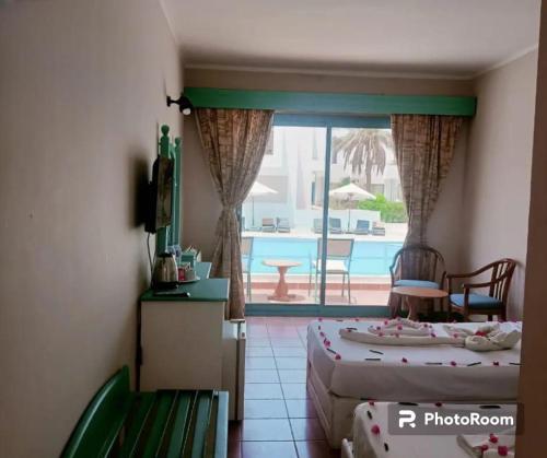 a bedroom with two beds and a view of a pool at Badawia Sharm Resort in Sharm El Sheikh