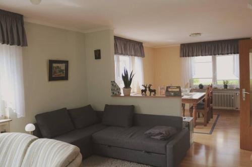 a living room with a couch and a table at Zwei Hirschen, 3 Sterne Ferienappartement in Hirschberg