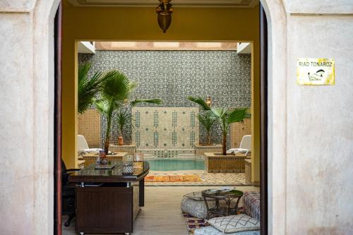 una camera con piscina, tavolo e sedie di Riad Tonaroz a Marrakech