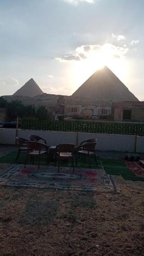 a group of tables and chairs with mountains in the background at Elkhaima motel in Giza