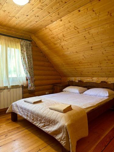 a bedroom with a bed in a log cabin at База відпочинку ШИПОВЕЦЬ in Poroškov