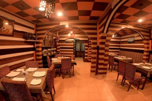 un restaurante con paredes de madera, mesas y sillas en Goroomgo Broadway Anexy Darjeeling Near Mall Road - Best Service Awarded, en Darjeeling