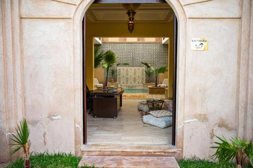 an archway into a patio with a chair and a table at Riad Tonaroz in Marrakech