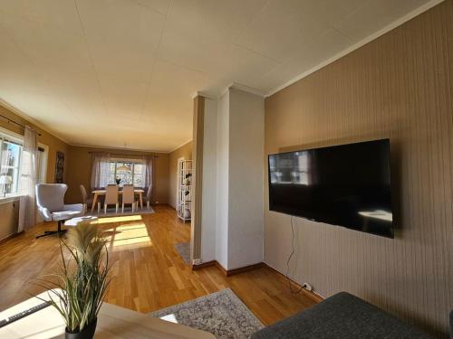 a living room with a flat screen tv on the wall at Sentrumsnær enebolig med 4 soverom in Skien