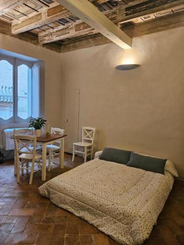 a bedroom with a bed and a table with chairs at La Dimora di Corso Marconi in Fermo