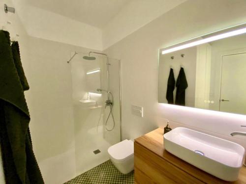 a bathroom with a sink and a toilet and a mirror at Mia's Apartment in Las Palmas de Gran Canaria