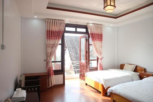 een slaapkamer met 2 bedden en een groot raam bij May Nui Sa Pa Hostel in Sa Pa