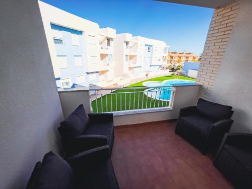 un balcón con 2 sillas y una piscina en Sunny Three bedroom apartment, en San Pedro del Pinatar