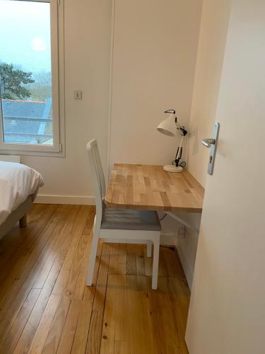 Cette chambre comprend un bureau avec une lampe et un lit. dans l'établissement L’Espadon, à Saint-Nazaire