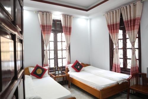two beds in a room with windows at May Nui Sa Pa Hostel in Sa Pa