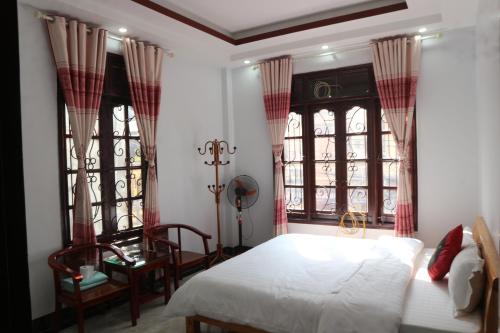 a bedroom with a bed and two windows at May Nui Sa Pa Hostel in Sa Pa