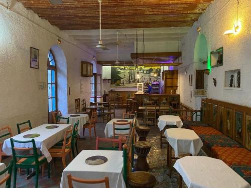 un restaurant avec des tables et des chaises blanches dans une salle dans l'établissement HOTEL DU PALAIS, à Saint-Louis