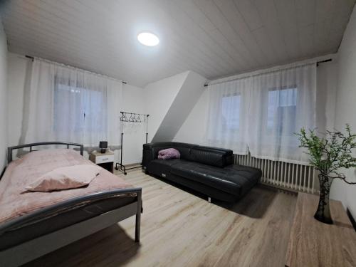 een slaapkamer met een bed en een bank bij Am Mariental 11 in Hankensbüttel