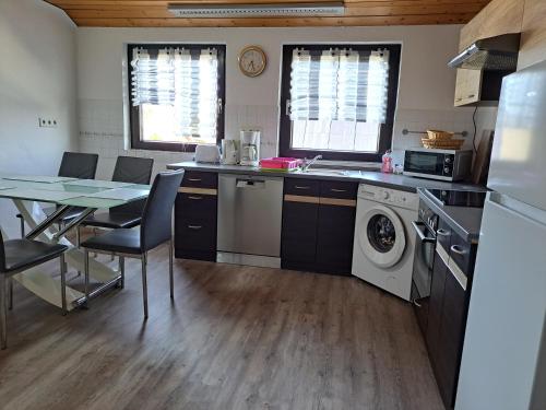 a kitchen with a table and a washing machine at Am Mariental 11 in Hankensbüttel