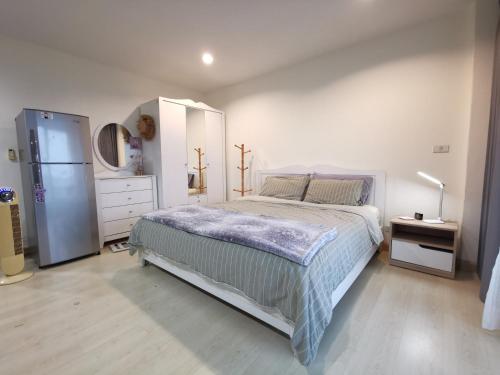 a bedroom with a bed and a dresser and a refrigerator at The Beach Bangsaen Condo Sea View Room 327-62 Top Floor-Free Netflix in Ban Bang Saen (1)