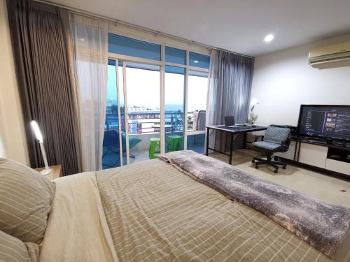 バンバンセーンにあるThe Beach​ Bangsaen​ Condo​のベッドルーム1室(ベッド1台、デスク、コンピュータ付)