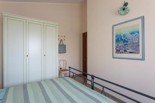 a bedroom with a bed and a picture on the wall at Amazing BAY VIEW-BEACH BOUTIQUE Apartment VELAMEIGA in Funtana Meiga