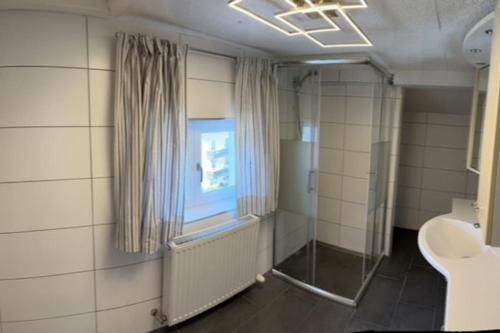 a bathroom with a shower and a sink and a window at Haus Schmidhuber Wohnung 4 in Grossgmain