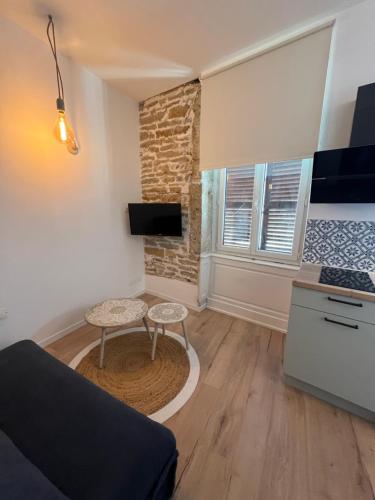 ein Wohnzimmer mit einem Sofa und einem Tisch in der Unterkunft L’appartement lumière in Bourg-en-Bresse