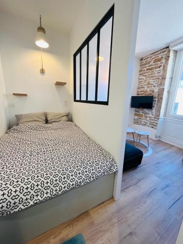 Schlafzimmer mit einem Bett und einem Fenster in der Unterkunft L’appartement lumière in Bourg-en-Bresse