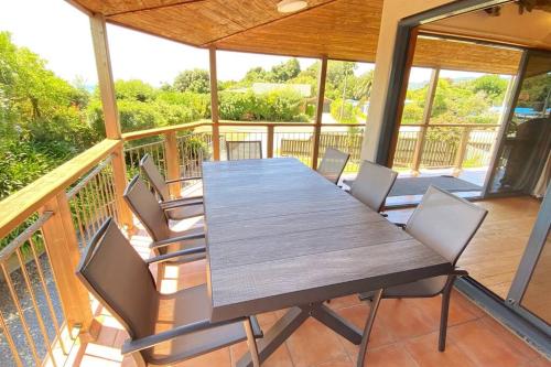 a wooden table and chairs on a balcony at Pohara Tides - Poharas Beach Getaway in Pohara