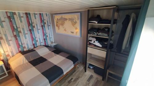 een kleine slaapkamer met een bed en een kast bij Chalet/Mobilhome Domaine des Canebières (Var) in Le Muy