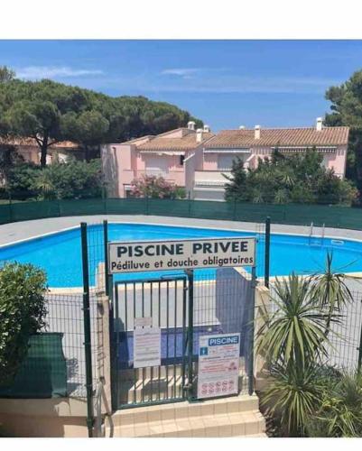 une clôture avec un panneau placé à côté d'une piscine dans l'établissement Eurêka Le cap d agde T2, au Cap d'Agde