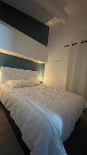 une chambre avec un lit blanc avec un mur bleu dans l'établissement Eurêka Le cap d agde T2, au Cap d'Agde