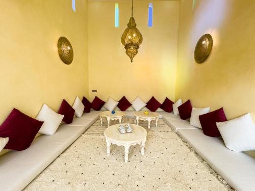 a room with red and white pillows and a table at Riad Tonaroz in Marrakech