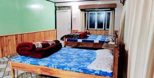a room with two beds and a chair in it at India Tours Only Smriti Homestay in Rongli